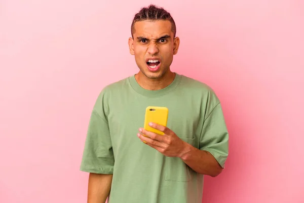 Młody Wenezuelczyk Trzyma Telefon Komórkowy Odizolowany Różowym Tle Krzycząc Bardzo — Zdjęcie stockowe