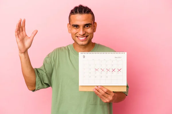 Joven Venezolano Sosteniendo Calendario Aislado Sobre Fondo Rosa Recibiendo Una — Foto de Stock