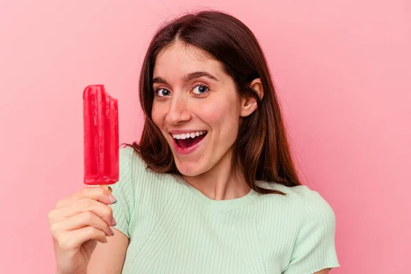 若い白人女性はピンクの背景に隔離されたアイスクリームを持っています — ストック写真
