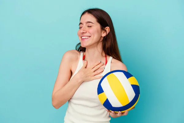 Joven Mujer Caucásica Jugando Voleibol Aislado Sobre Fondo Azul Ríe —  Fotos de Stock
