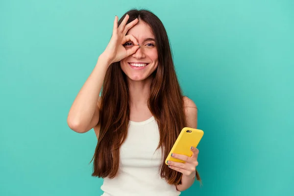 Ung Kaukasiska Kvinna Som Håller Mobiltelefon Isolerad Blå Bakgrund Glada — Stockfoto