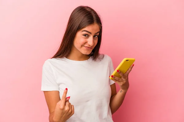 Młoda Kaukaska Kobieta Trzyma Telefon Komórkowy Odizolowany Różowym Tle Wskazując — Zdjęcie stockowe