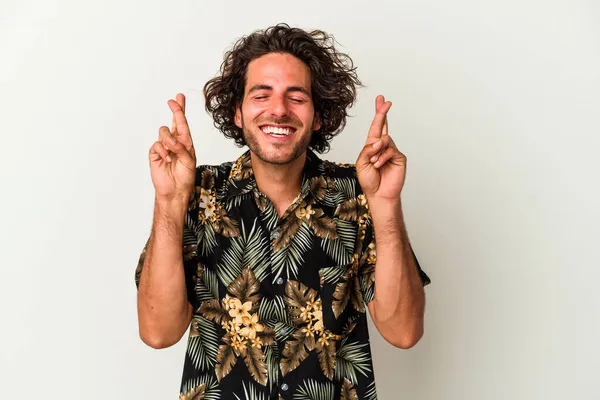 Beyaz arka planda izole genç beyaz adam şans dilemek için şans diliyor.