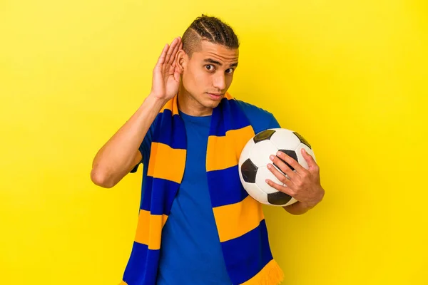 Joven Venezolano Viendo Fútbol Aislado Sobre Fondo Amarillo Tratando Escuchar —  Fotos de Stock