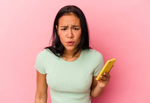 Ung Venezuelansk Kvinna Som Håller Mobiltelefon Isolerad Rosa Bakgrund Skriker — Stockfoto