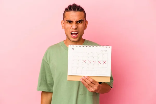 Młody Wenezuelczyk Człowiek Trzyma Kalendarz Odizolowany Różowym Tle Krzycząc Bardzo — Zdjęcie stockowe