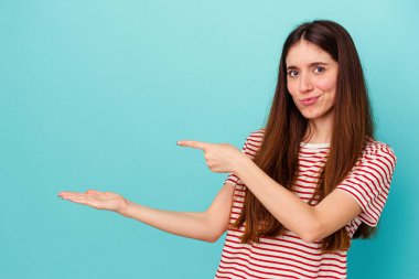 Mavi arka planda izole edilmiş beyaz bir kadın. Elinde palmiye ağacının fotokopisini tutarken heyecanlı..