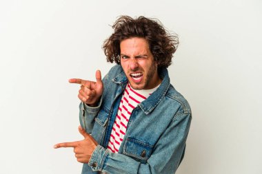 Beyaz arka planda izole edilmiş genç beyaz bir adam işaret parmağıyla fotokopi alanını işaret ederek heyecan ve arzusunu ifade ediyor..