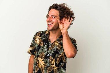 Beyaz arka planda izole edilmiş genç beyaz adam bir dedikoduyu dinlemeye çalışıyor..