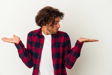 Beyaz arka planda izole edilmiş genç beyaz bir adam. Kafası karışmış ve omuz silkiyor. Kopya alanını tutmak için..