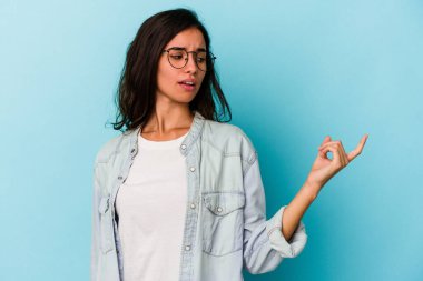 Mavi arka planda izole edilmiş genç beyaz kadın sanki seni davet ediyormuş gibi seni işaret ediyor..