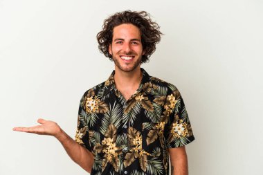 Beyaz arka planda izole edilmiş genç beyaz bir adam bir palmiye üzerinde fotokopi alanı gösteriyor ve belinde başka bir el tutuyor..