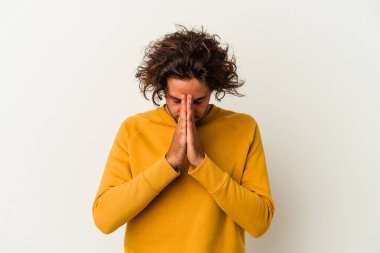 Beyaz arka planda izole edilmiş genç beyaz adam dua ediyor, bağlılık gösteriyor, dindar biri ilahi ilham arıyor..