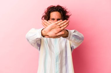 Pembe fırında izole edilmiş genç beyaz adam inkar jesti yapıyor.