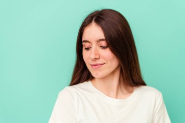 Genç beyaz kadın mavi arka planda izole edilmiş.