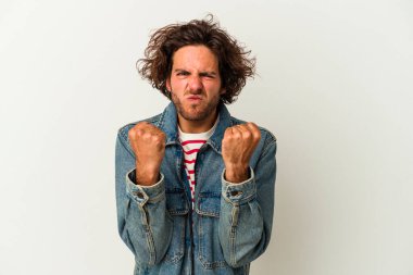 Beyaz arka planda izole edilmiş genç beyaz bir adam yumruğunu kameraya gösteriyor, agresif bir yüz ifadesi..