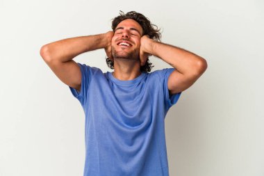 Beyaz arka planda izole olmuş genç beyaz bir adam ellerini başının üstünde tutarak neşeyle gülüyor. Mutluluk kavramı.