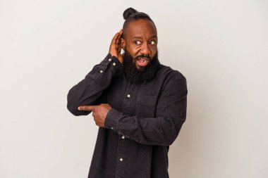 Pembe arka planda sakallı Afrikalı Amerikalı bir adam bir dedikoduyu dinlemeye çalışıyor..