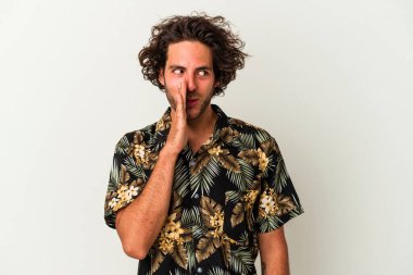 Beyaz arka planda izole edilmiş genç beyaz bir adam gizli bir sıcak fren haberi veriyor ve yana bakıyor.