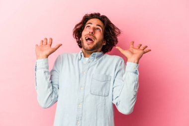 Pembe fırında izole edilmiş genç beyaz adam gökyüzüne haykırıyor, yukarı bakıyor, hayal kırıklığına uğramış..