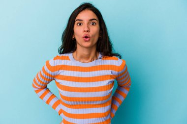 Mavi arka planda izole edilmiş beyaz bir kadın gördüğü bir şey yüzünden şoka uğruyor..