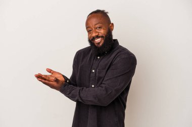 Pembe arka planda sakallı Afrikalı Amerikalı bir adam. Elinde palmiyesinde bir kopya alanı var..