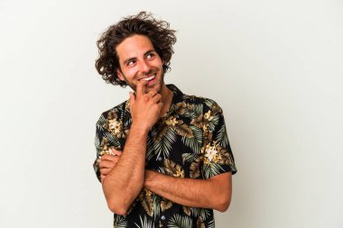 Beyaz arka planda izole edilmiş genç beyaz bir adam rahatlamış bir şeyin fotokopi odasına baktığını düşünüyor..