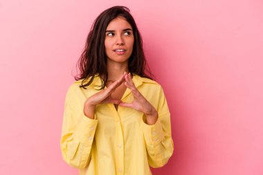 Kafkasyalı genç bir kadın pembe arka planda izole edilmiş bir plan yapıyor, bir fikir kuruyor..