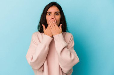 Mavi arka planda izole edilmiş genç beyaz kadın elleri ve elleri endişeli görünüyor..