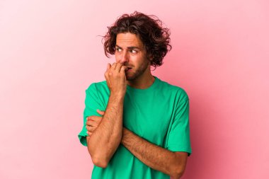 Kafkasyalı genç bir adam pembe bakkal bahçesinde izole edilmiş tırnaklarını yiyor, gergin ve çok endişeli..