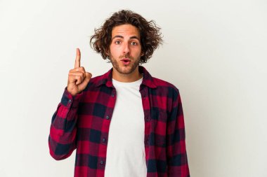 Beyaz arka planda izole edilmiş genç beyaz adam ağzı açık bir şekilde üst tarafı işaret ediyor..