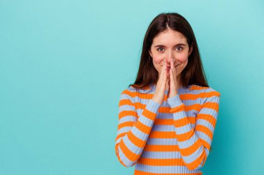 Kafkasyalı genç bir kadın mavi arka planda izole edilmiş bir plan kuruyor, bir fikir kuruyor..