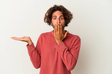 Beyaz arka planda izole edilmiş genç beyaz adam, avuç içi fotokopi alanını elinde tutmaktan etkilenmiş..