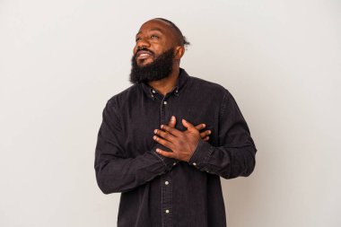 Pembe arka planda sakallı Afro-Amerikan bir adam dost canlısı bir ifadeye sahip, avuçlarını göğsüne bastırıyor. Aşk konsepti.