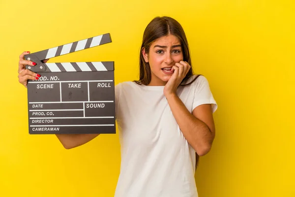 Young Caucasian Woman Holding Clapperboard Isolated White Background Biting Fingernails — Stock Photo, Image