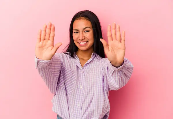 年轻的委内瑞拉女子在粉色背景上被隔离 手举着第十号 — 图库照片