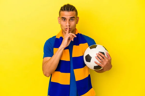 Νεαρός Βενεζουανός Που Παρακολουθεί Ποδόσφαιρο Απομονωμένος Κίτρινο Φόντο Κρατώντας Μυστικό — Φωτογραφία Αρχείου