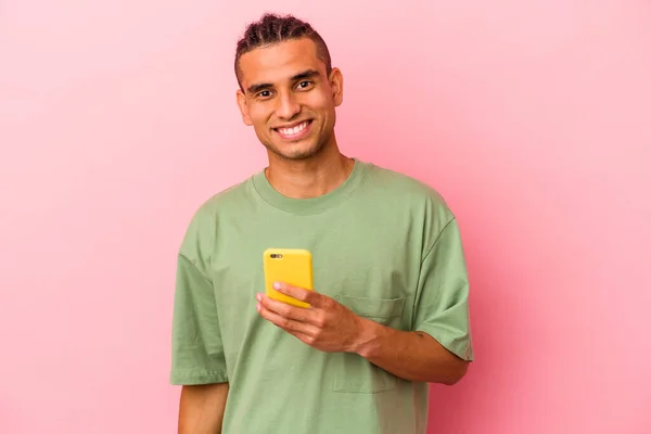 Młody Wenezuelczyk Trzyma Telefon Komórkowy Odizolowany Różowym Tle Szczęśliwy Uśmiechnięty — Zdjęcie stockowe