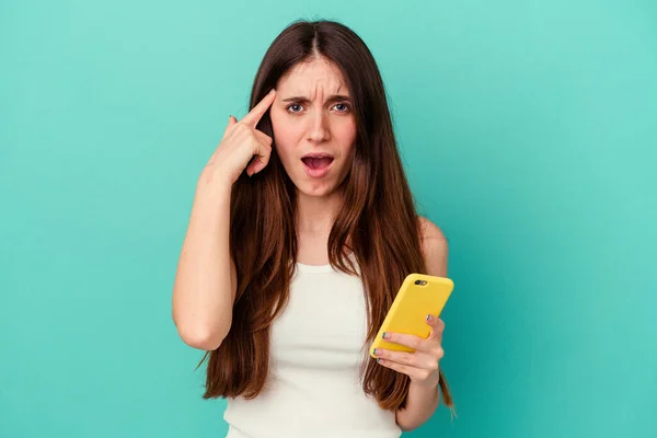 Joven Mujer Caucásica Sosteniendo Teléfono Móvil Aislado Sobre Fondo Azul — Foto de Stock