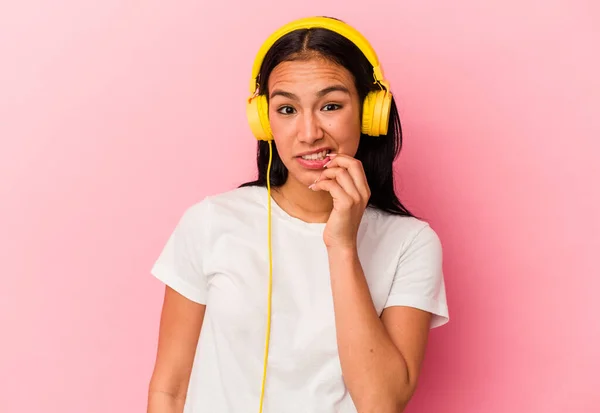 Jovem Venezuelana Ouvindo Música Isolada Fundo Rosa Mordendo Unhas Nervosa — Fotografia de Stock