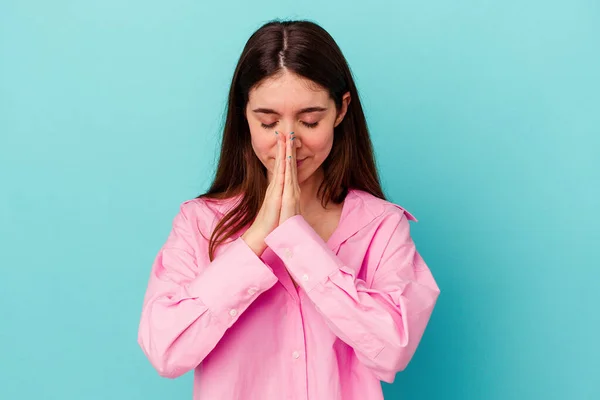 Kafkasyalı Genç Kadın Mavi Arka Planda Izole Edilmiş Dua Ediyor — Stok fotoğraf