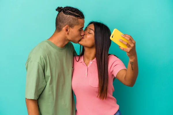 一对年轻的拉丁夫妇 带着一部蓝色背景的手机 — 图库照片