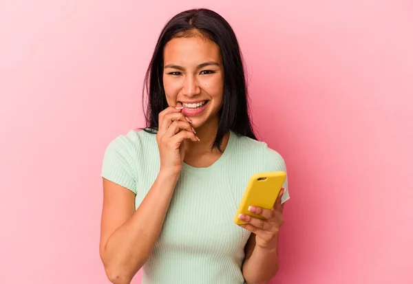 Joven Venezolana Sosteniendo Teléfono Móvil Aislado Sobre Fondo Rosa Mordiendo —  Fotos de Stock