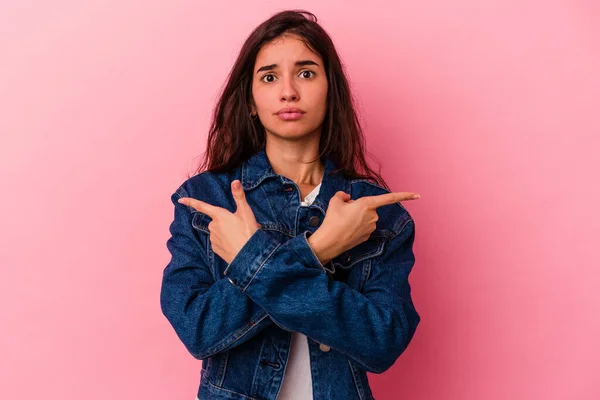 Ung Kaukasisk Kvinna Isolerad Rosa Bakgrund Pekar Sidled Försöker Välja — Stockfoto