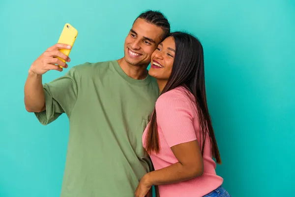 Jeune Couple Latin Avec Téléphone Portable Isolé Sur Fond Bleu — Photo