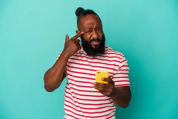拿着一部蓝色背景的手机的非裔美国人 用食指表示出失望的姿态 — 图库照片