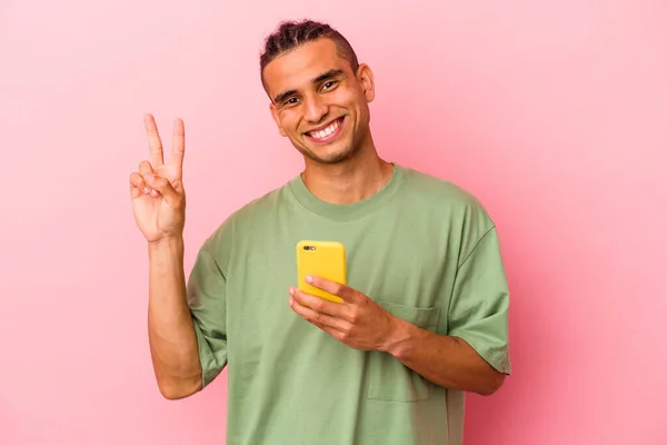 Młody Wenezuelczyk Trzymający Telefon Komórkowy Odizolowany Różowym Tle Radosny Beztroski — Zdjęcie stockowe