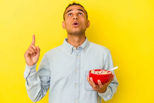 Joven Venezolano Sosteniendo Tazón Cereales Aislado Sobre Fondo Amarillo Apuntando —  Fotos de Stock