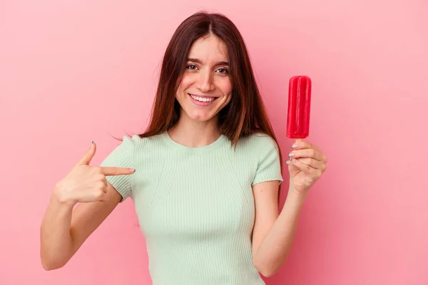 青い背景の人に手で指差すアイスクリームを持つ若い白人女性シャツコピースペース 誇りと自信 — ストック写真