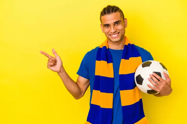 Joven Venezolano Observando Fútbol Aislado Sobre Fondo Amarillo Sonriendo Señalando —  Fotos de Stock